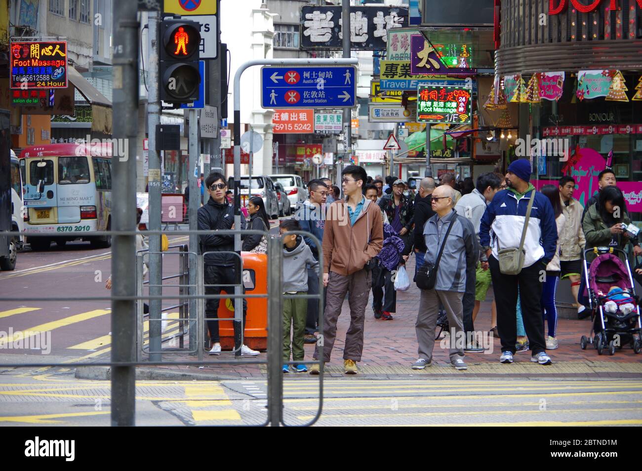 Hong Kong, Cina - 27 novembre 2016: Pedoni in attesa di zebra attraversando il semaforo rosso all'incrocio vicino alla Jordan e alla stazione della metropolitana di Austin ad Hongkon Foto Stock