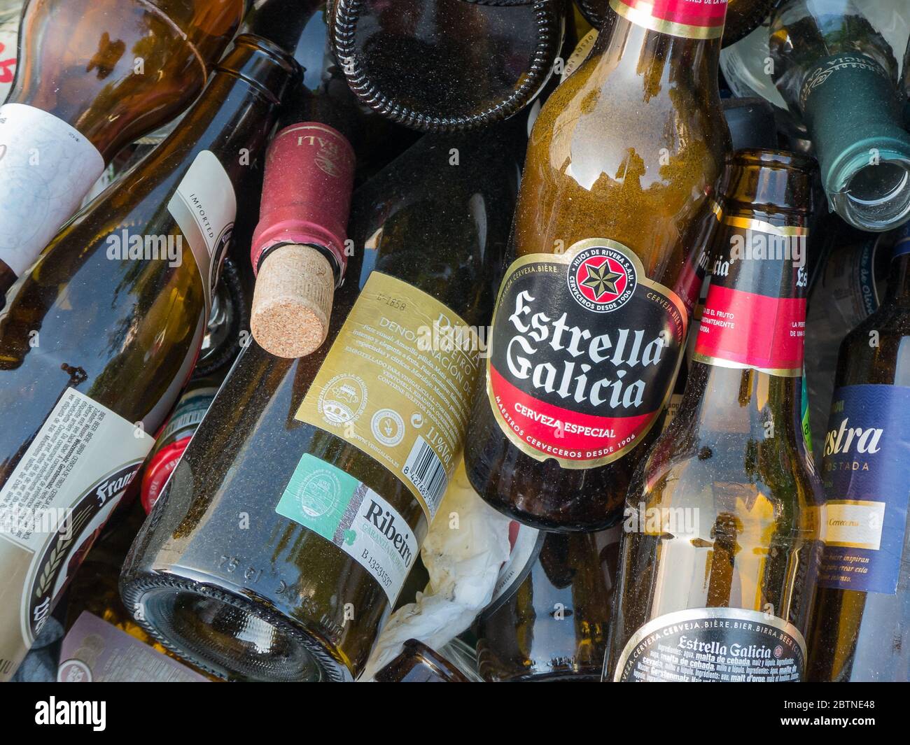 Da qualche parte in Spagna, 25 agosto 2018: Primo piano di bottiglie vuote di birra accatastate, in particolare Estrella; e vino Foto Stock