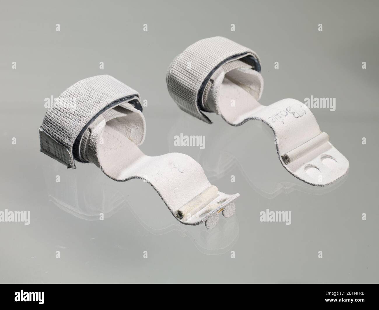 Impugnature irregolari utilizzate da Gabby Douglas nelle Olimpiadi di Londra del 2012. Due impugnature non uniformi utilizzate da Gabby Douglas nelle Olimpiadi di Londra del 2012. Le parti anteriori delle impugnature sono dotate di cinghie arrotondate e di due (2) fori per le dita su ciascuna impugnatura. Questi sono per il dito anulare e il dito centrale. L'impugnatura b. ha del nastro di tessuto tra i due fori per le dita. Foto Stock
