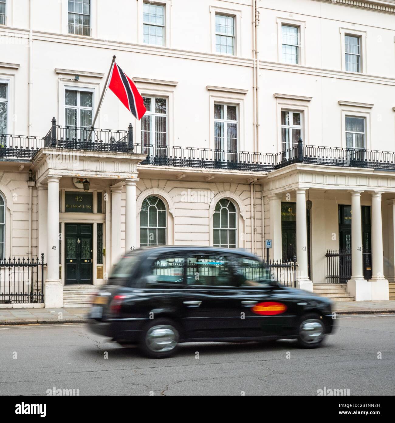 L'alta Commissione di Trinidad & Tobago a Belgravia, un distretto di Londra con un'alta concentrazione di ambasciate. Sfocatura del movimento sul taxi in primo piano. Foto Stock