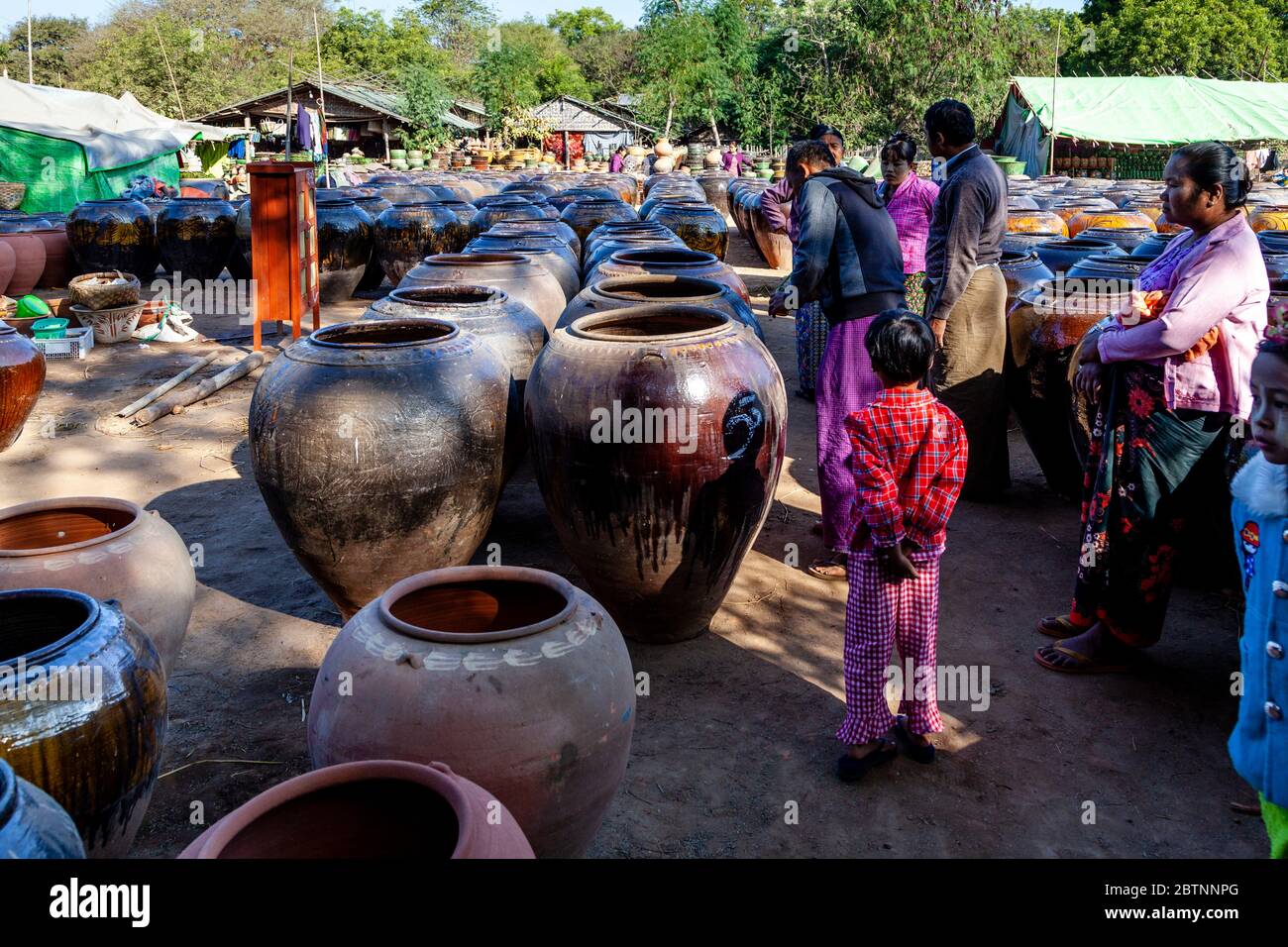 Persone birmane che acquistano grandi contenitori di stoccaggio, Tempio di Ananda, Bagan, Regione Mandalay, Myanmar. Foto Stock