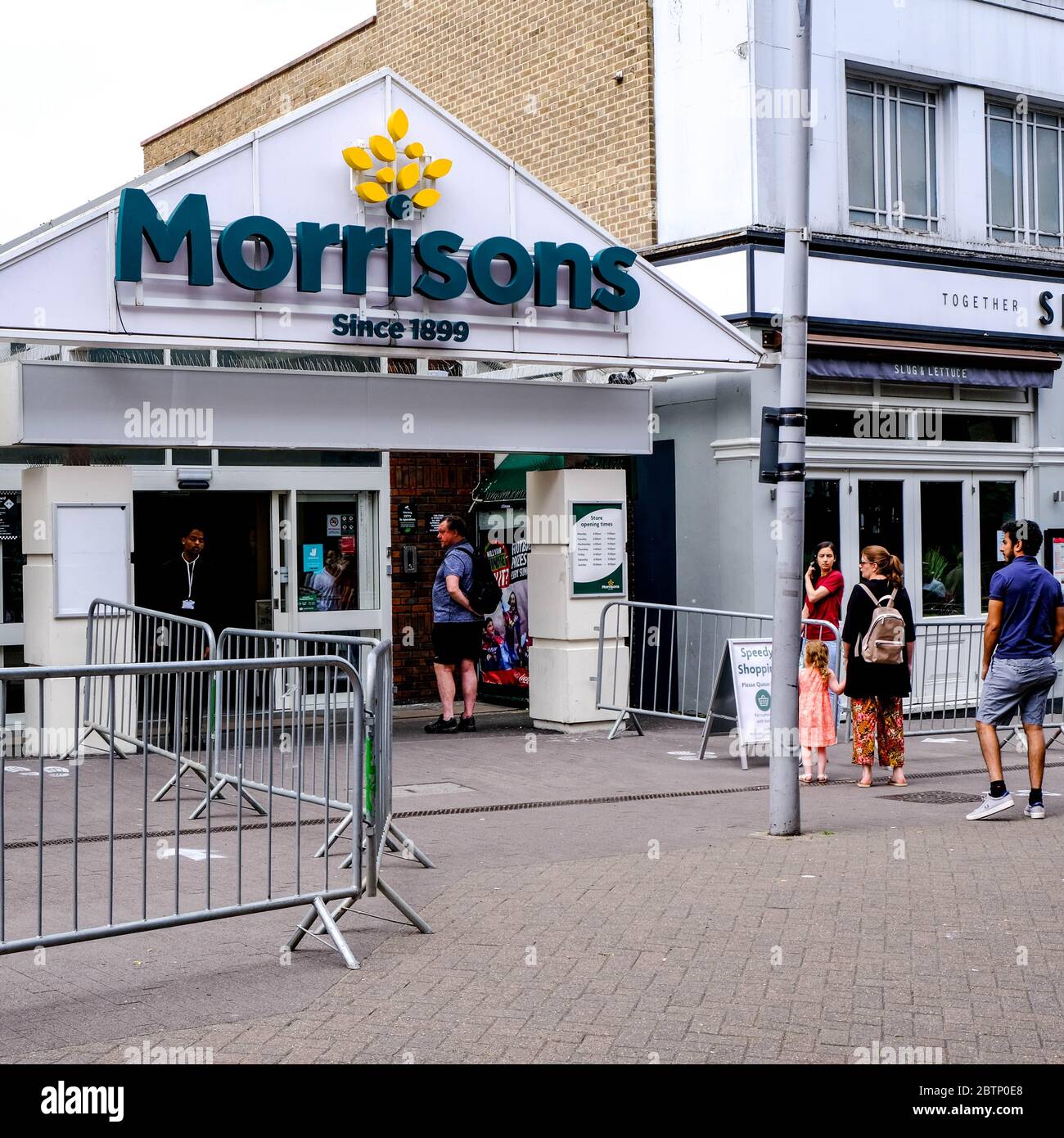 Clienti in coda fuori DA UN supermercato Morrisons nel sud di Londra osservando le distanze sociali Foto Stock