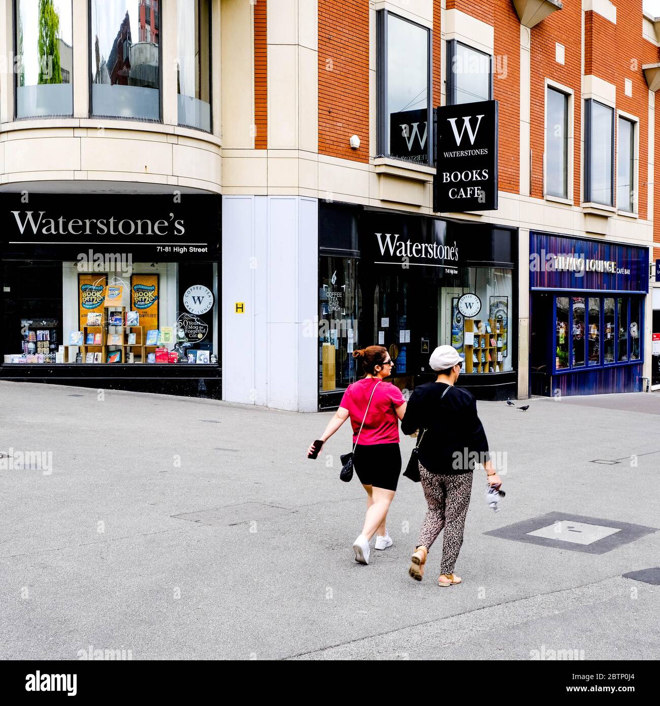 Due donne anonime passano davanti A UN negozio di libri di Waterstone chiuso a Londra sud durante il Coronavirus Lockdown Foto Stock