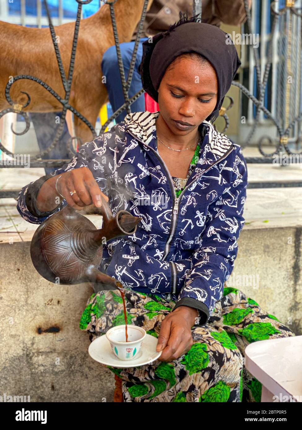 Donna che versa il caffè in una tazza, depressione Danakil, Afar Regione, Etiopia, Africa Foto Stock
