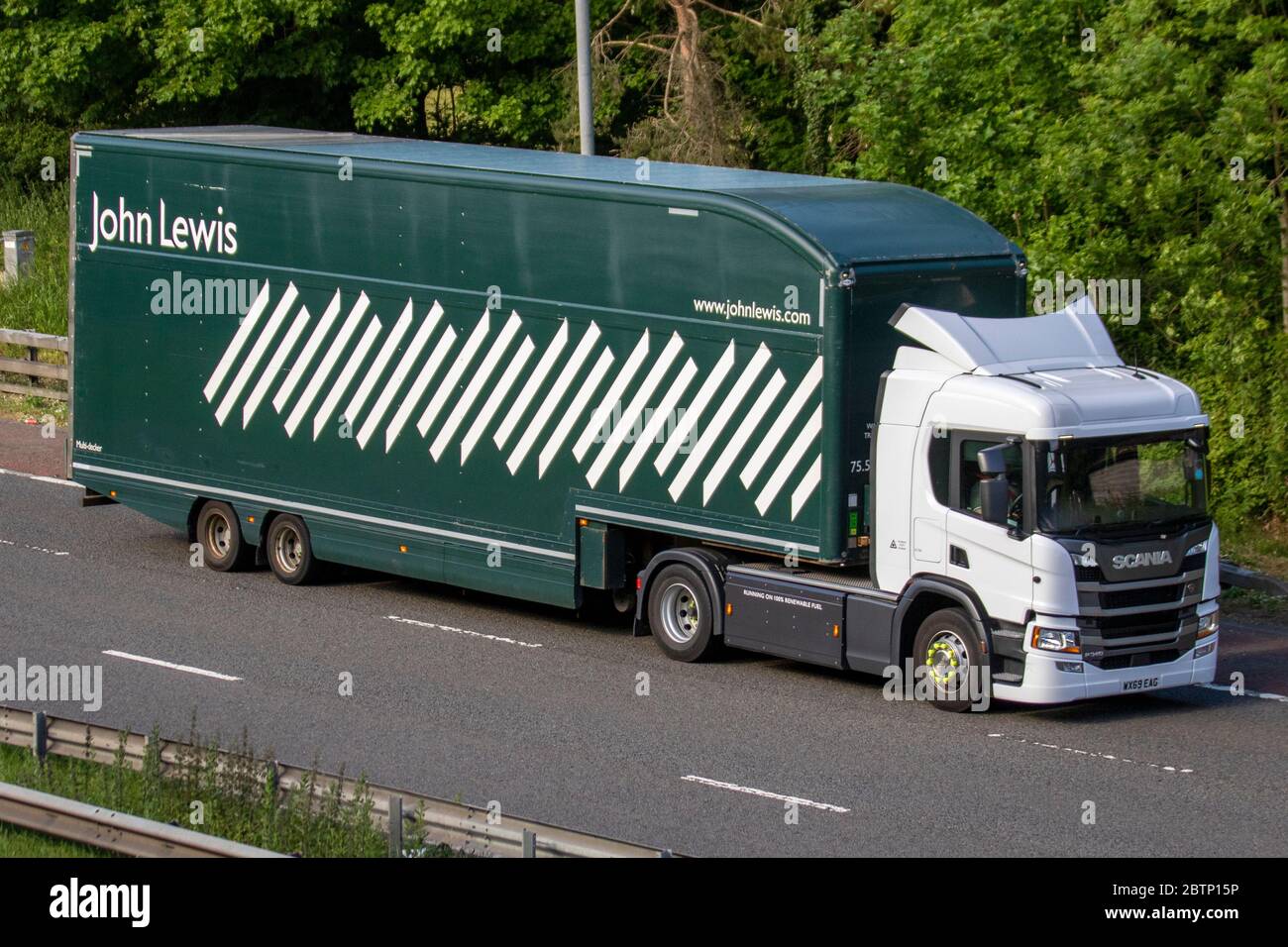 John Lewis; camion di consegna di trasporto, camion verde articolato, trasporto, camion, Cargo cargo, high-end grandi magazzini veicolo, trasporto commerciale europeo HGV, M6 a Manchester, Regno Unito Foto Stock