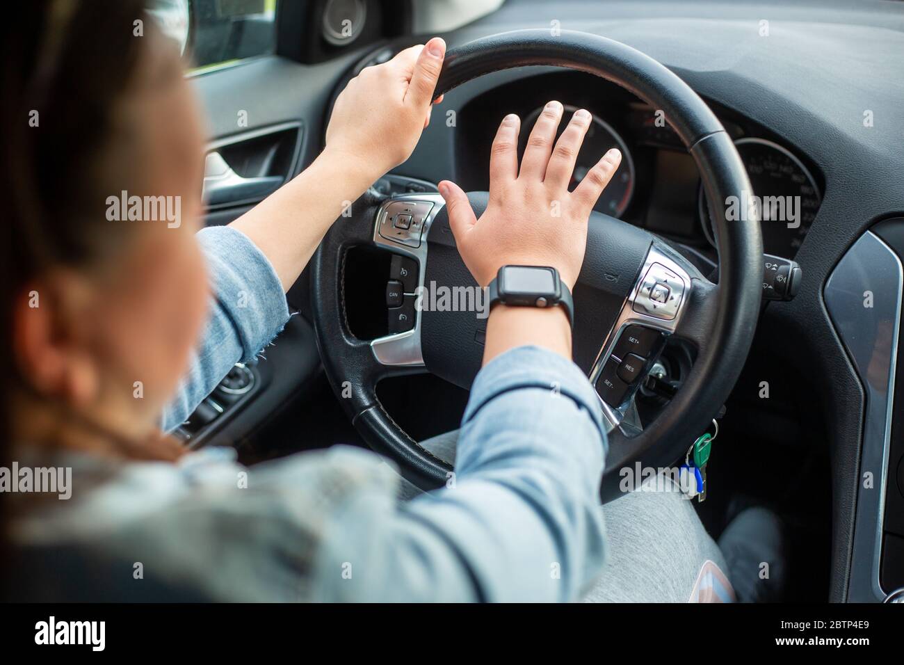 Giovane donna aggressiva driver con corno o trombe per le altre vetture, pericoloso driver Foto Stock