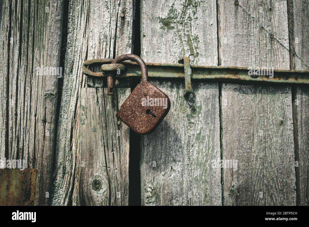 vecchio lucchetto arrugginito su porta in legno. serratura vintage aperta. concetto di protezione di sicurezza Foto Stock