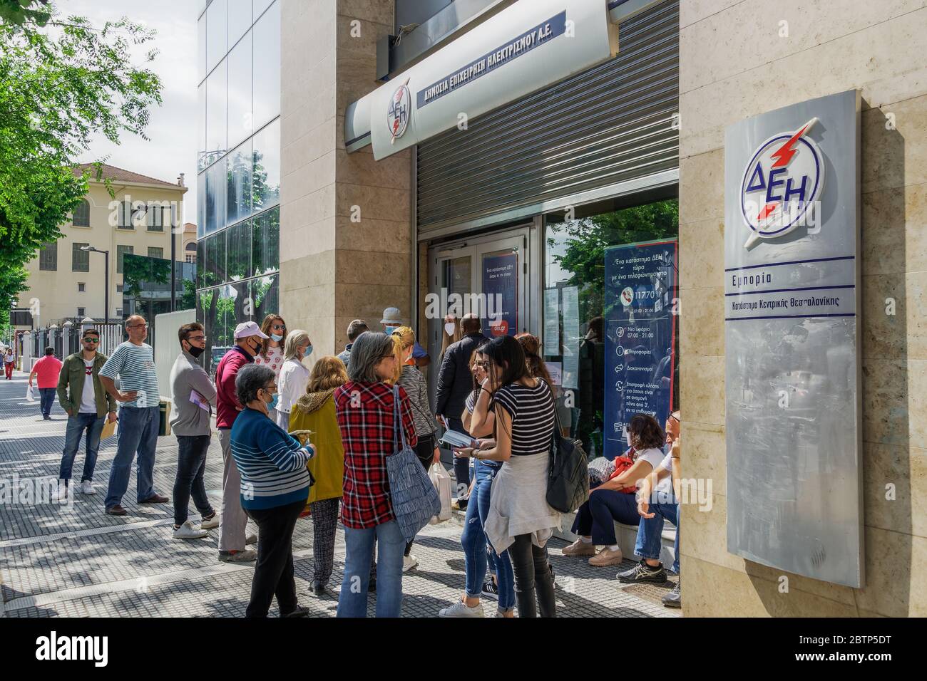 Salonicco, Grecia - maggio 25 2020: Le misure del coronavirus influiscono sulla vita quotidiana. I greci mantengono la distanza al di fuori DELLA DEI-Public Power Corporation per il deposito di elettricità, in linea con la decisione di impedire COVID-19. Foto Stock