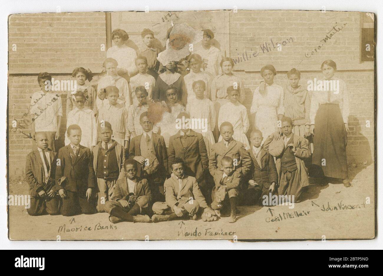 Fotografia di scolari e insegnanti. Una fotografia in bianco e nero dei bambini della scuola e un insegnante, che si posa in cinque file, davanti ad un edificio. Foto Stock