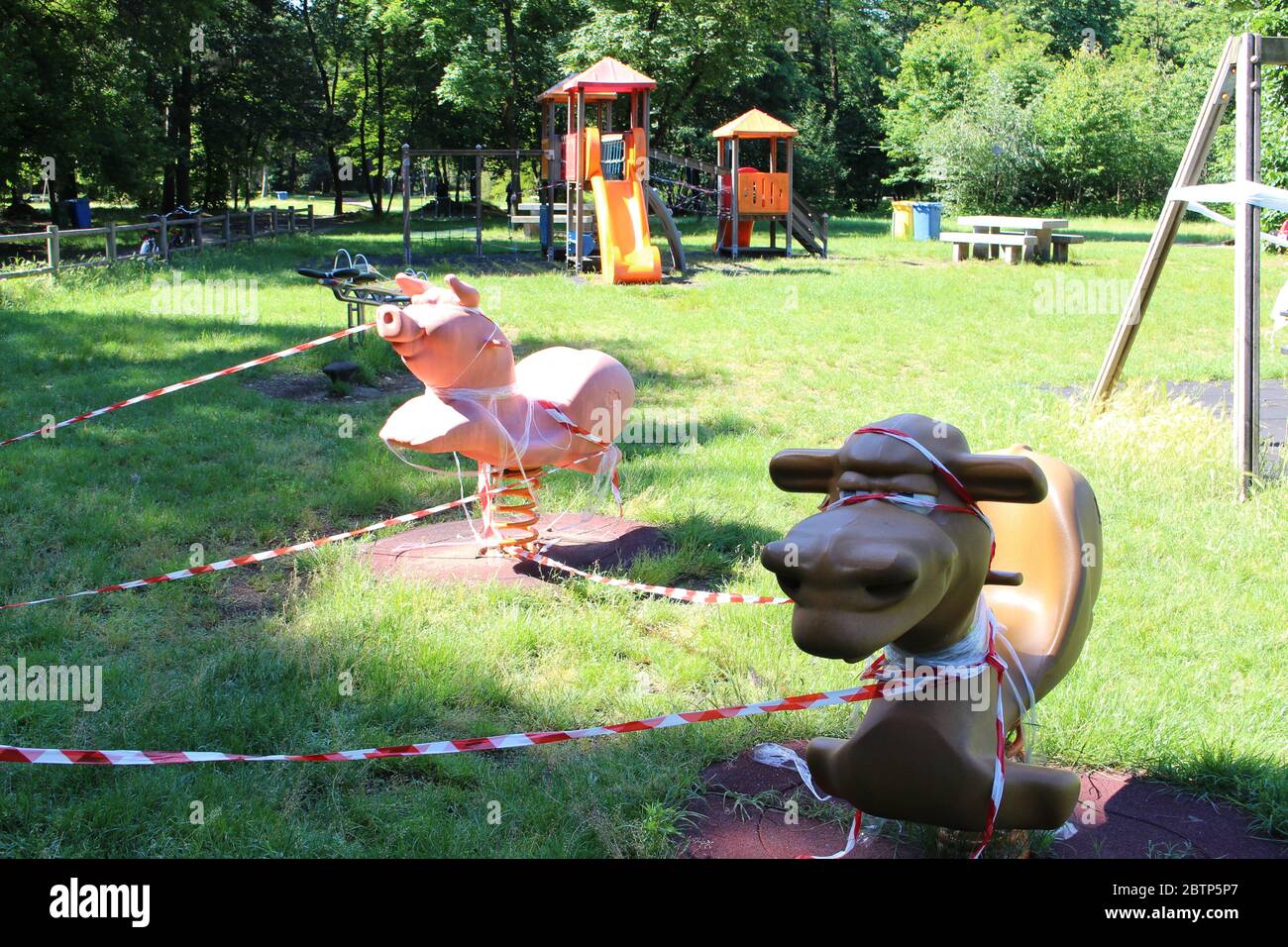 Busto Arsizio, Varese / Italia - 05 27 2020: Il parco giochi per bambini in Italia, chiuso a causa del virus Covid-19. Isolato con nastro bianco e rosso. Foto Stock