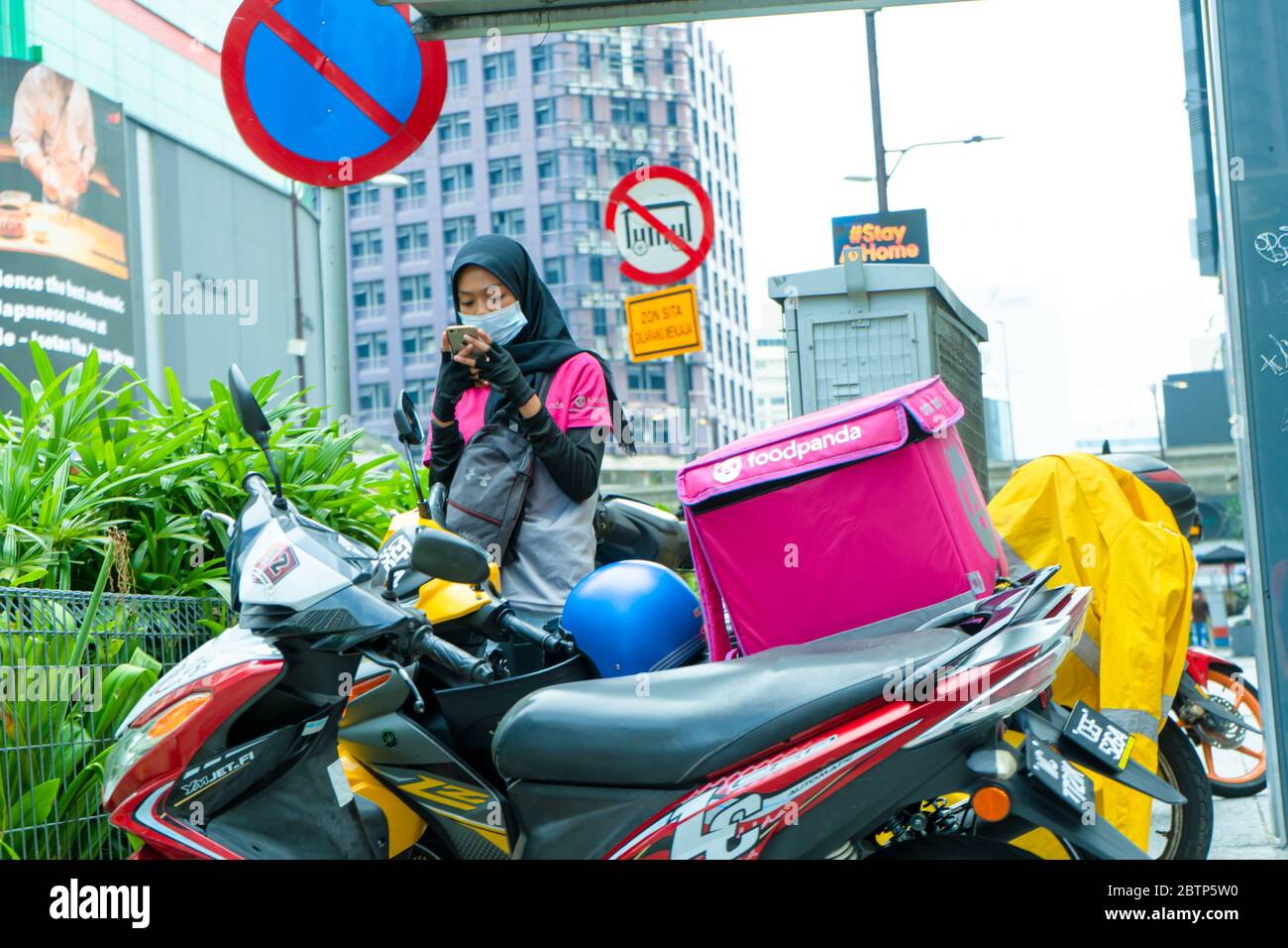 Corriere di un servizio di consegna di cibo popolare in Malesia su una bicicletta. Ordine di cibo a casa. Foto Stock