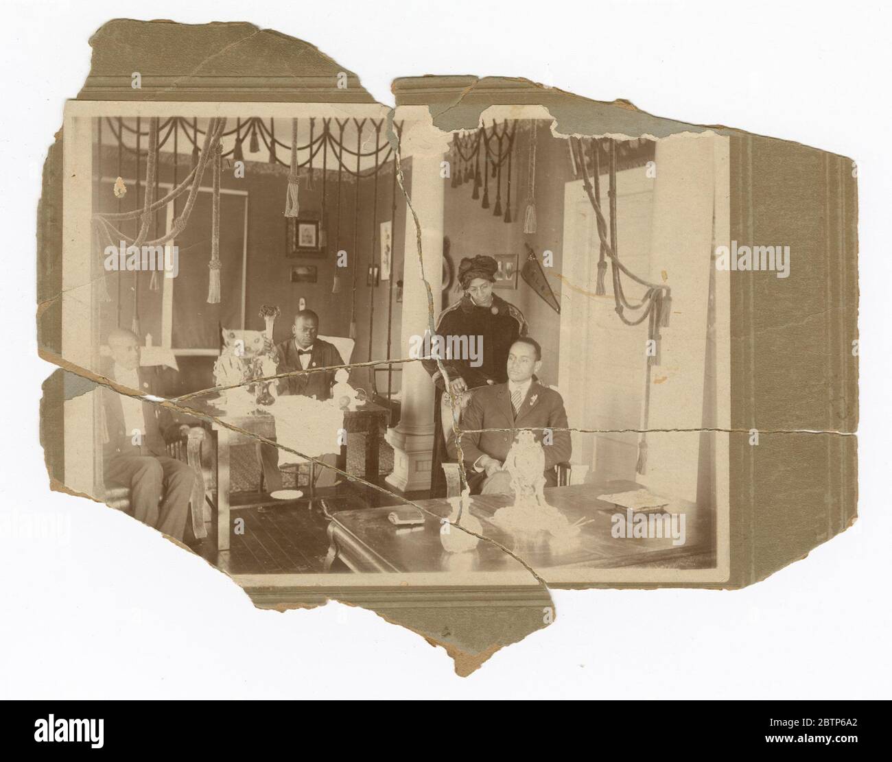 Stampa fotografica di 3 uomini e donne in posa in ambiente interno. Una fotografia in bianco e nero di Beatrice Cloman Dedman e tre (3) uomini in un salotto. Beatrice Dedman è al centro-destra, in piedi dietro una sedia in cui uno degli uomini è seduto. Le mani si appoggiano sulla schiena della sedia. Foto Stock Stampa fotografica di 3 uomini e donne in posa in ambiente interno. Una fotografia in bianco e nero di Beatrice Cloman Dedman e tre (3) uomini in un salotto. Beatrice Dedman è al centro-destra, in piedi dietro una sedia in cui uno degli uomini è seduto. Le mani si appoggiano sulla schiena della sedia. Foto Stock