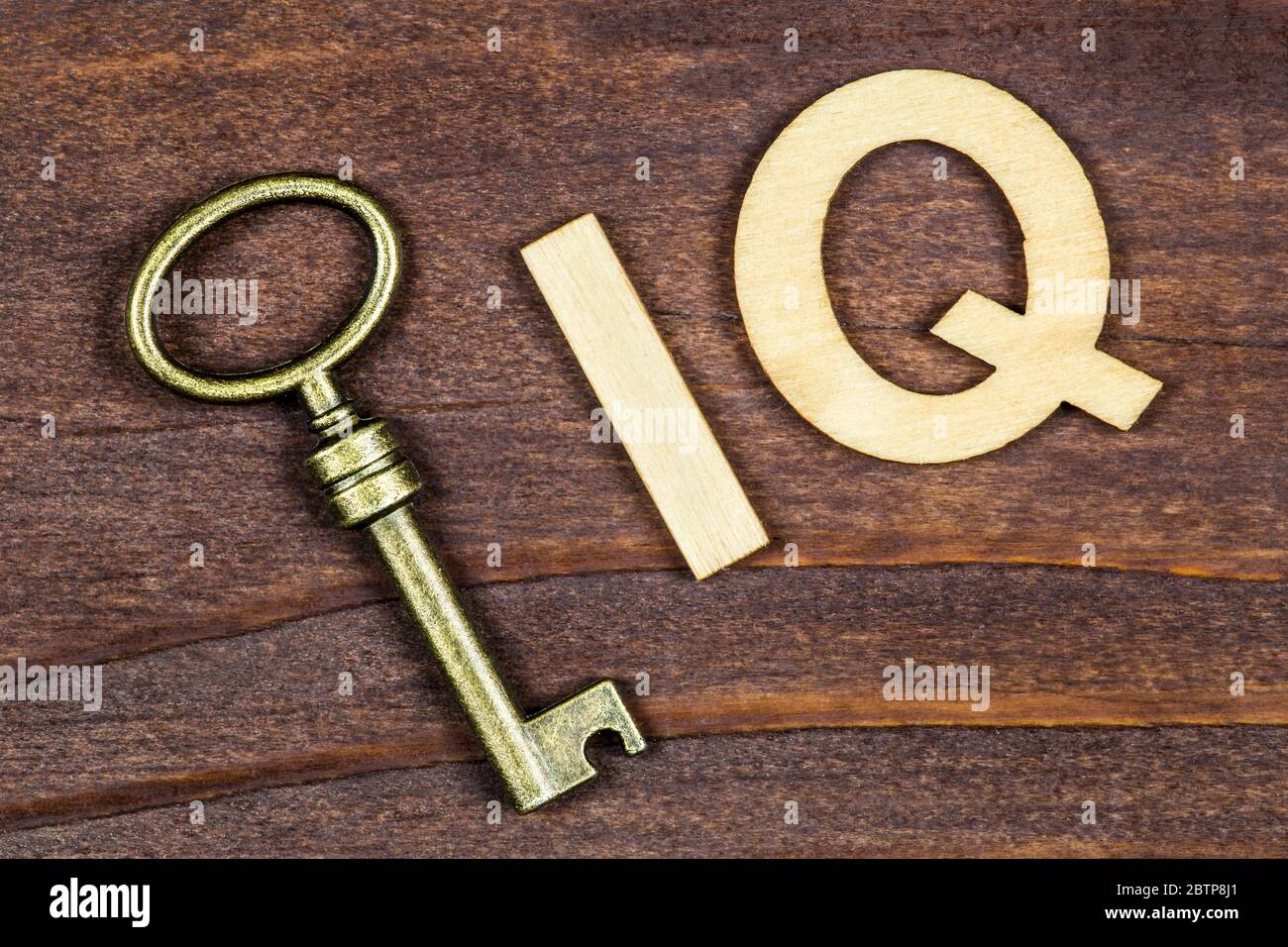Quoziente di intelligenza, concetto di test iq, chiave con lettere su sfondo di legno Foto Stock