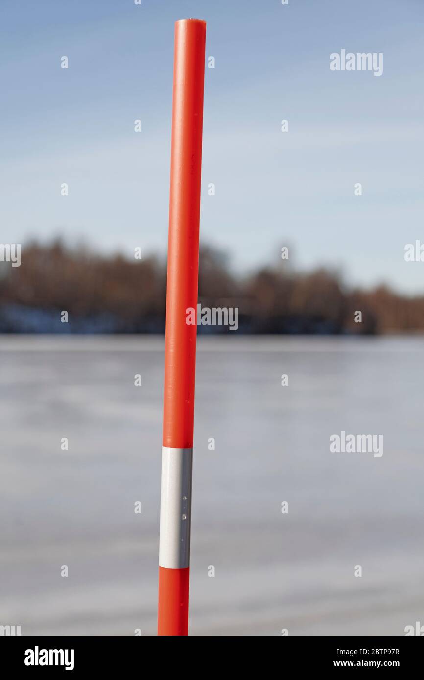 un bastone arancione con materiale riflettente per contrassegnare l'inizio e la fine della strada quando è invernale Foto Stock