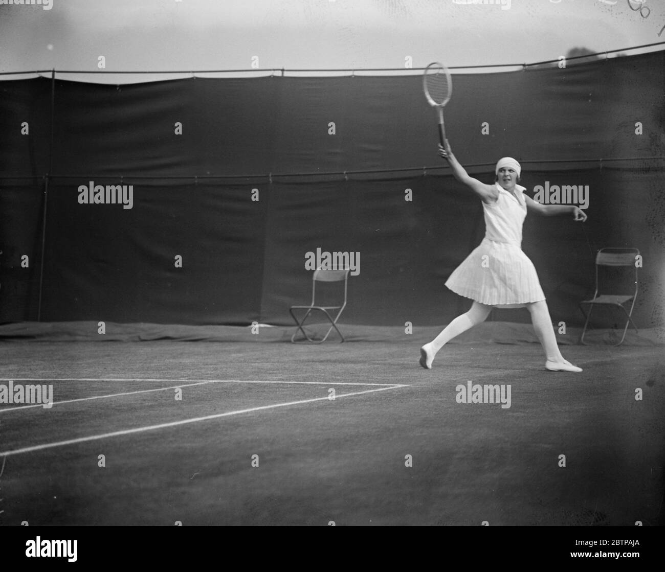 Tennis in prato a Wimbledon . Miss Betty Nuthall serve. 25 giugno 1929 Foto Stock