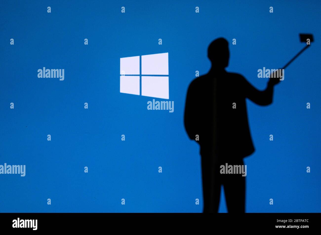 NEW YORK, STATI UNITI, 25. MAGGIO 2020: Sistema operativo grafico Microsoft Windows uomo scattare una foto sul telefono cellulare con selfie stick. . Logo aziendale su scre Foto Stock