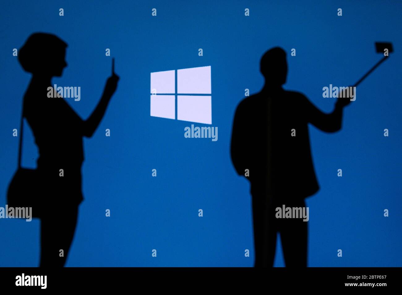 NEW YORK, STATI UNITI, 25. MAGGIO 2020: Sistema operativo grafico Microsoft Windows uomo e donna scattare una foto su mobile uomo usare selfie stick. Logo aziendale attivo Foto Stock