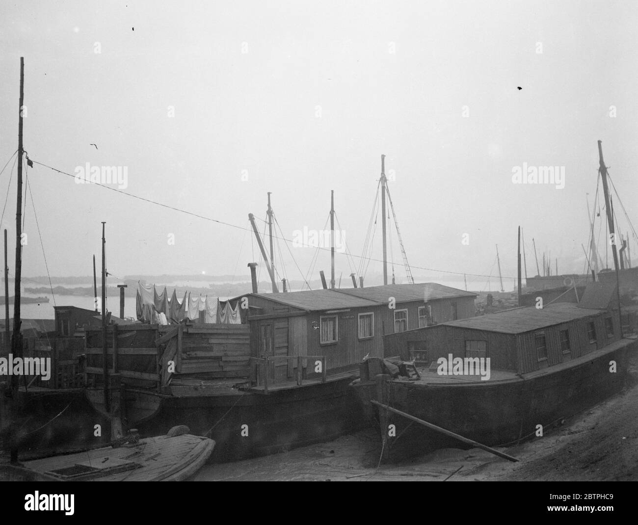 Risoluzione del problema dell'alloggiamento . In Bugsbies raggiungere , Charlton , centinaia di vecchie chiatte che in precedenza spianavano il Tamigi , sono poste a riposo , molti sono rotti quando la loro giornata è fatta . Una piccola colonia è stata sguazzata nella portata e molte delle più spaziose delle vecchie chiatte sono state convertite in case per i lavoratori fluviali . Una vista di alcune delle case chiatte in Bugsbies raggiungere , Charlton , Londra . 6 febbraio 1932 . Foto Stock