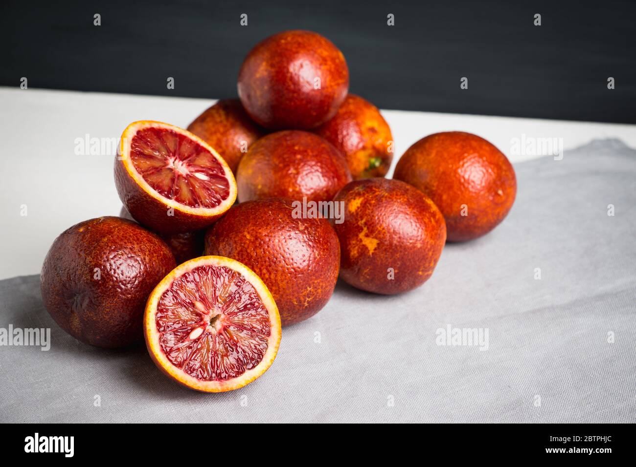 Arance siciliane rosse su sfondo di legno scuro. Profondità di campo poco profonda. Foto Stock