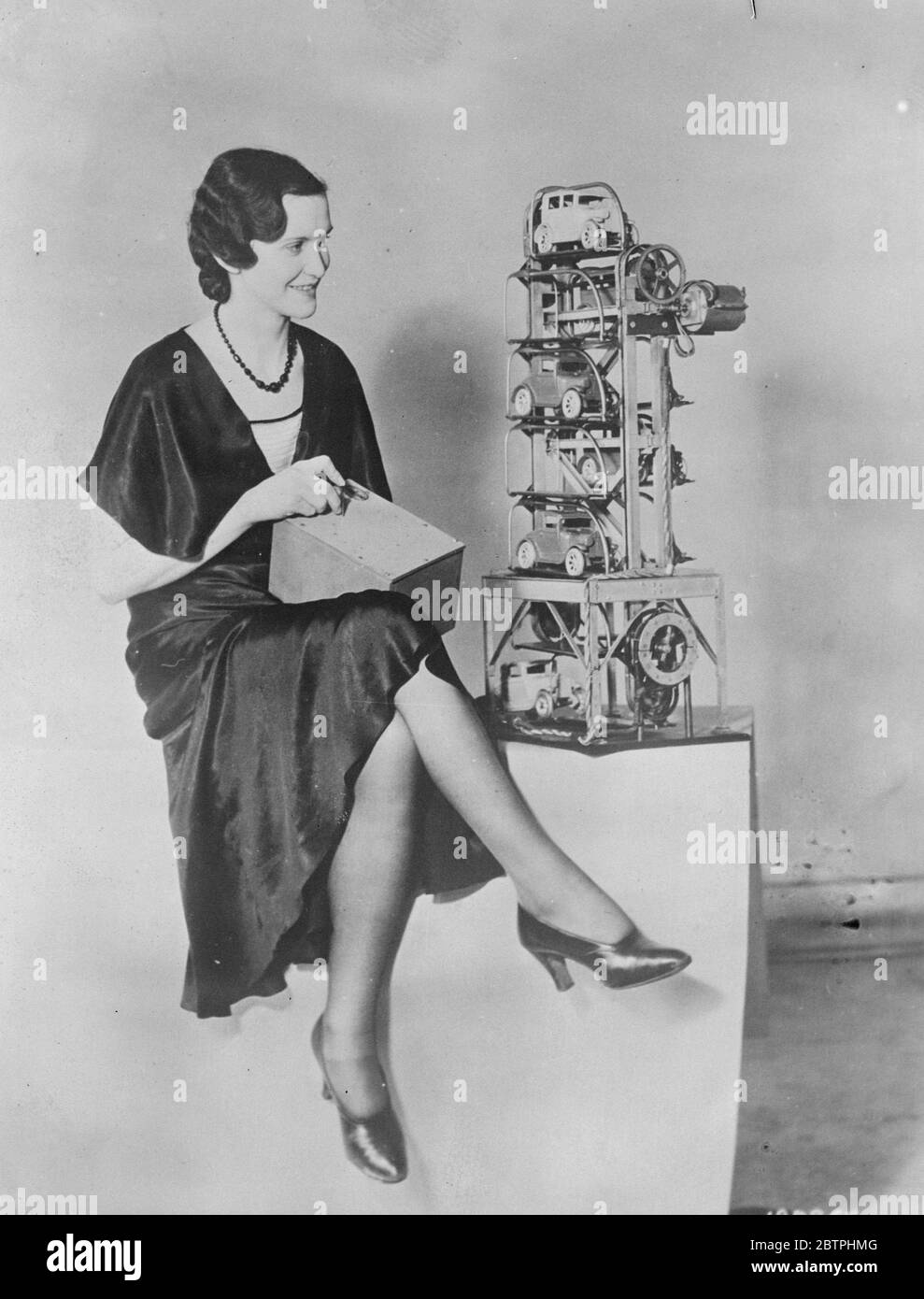 Risolvere la difficoltà di parcheggio . Una macchina automatica di parcheggio è stata inventata dalla Westinghouse Electric Company of America che si ritiene risolverà il problema del parcheggio auto in grandi città . La macchina lavora automaticamente l'utente che inserisce un perno in un foro corrispondente al numero della vettura richiesta e la vettura viene portata a livello stradale pronta per essere scacciata. Helen Nair che lavora un modello del parcheggio automatico. 31 marzo 1932 Foto Stock