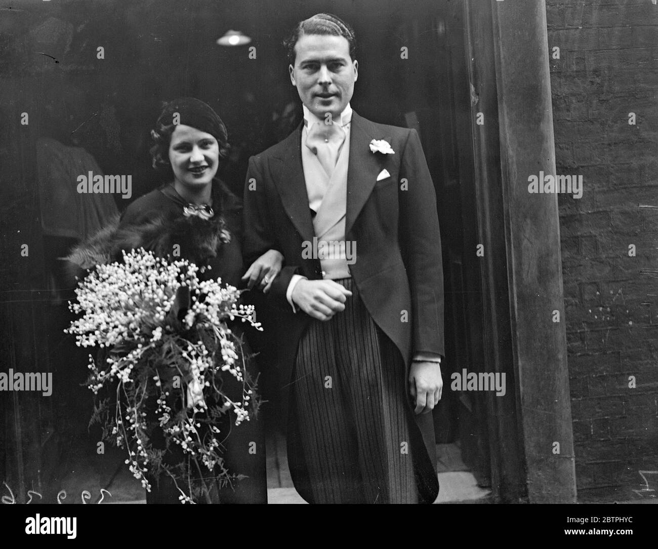 Società ragazza stewardess sposi . Il matrimonio di Miss June Child , figlia di Madame Davila de pena , la bella hostess colombiana , a MR. R Hanke , si è svolto nella chiesa dell' Assunzione Warwick Street , Londra . Miss June Child era la ragazza della società , che , con Miss Bunting Stephenson , nipote di Sir Denzil Cope , ha firmato come una stewardess su una nave da carico norvegese e ha lavorato il suo passaggio in Palestina all'inizio di quest'anno . Foto , lo sposo e lo sposo che lasciano la chiesa dopo la cerimonia . 14 novembre 1933 Foto Stock