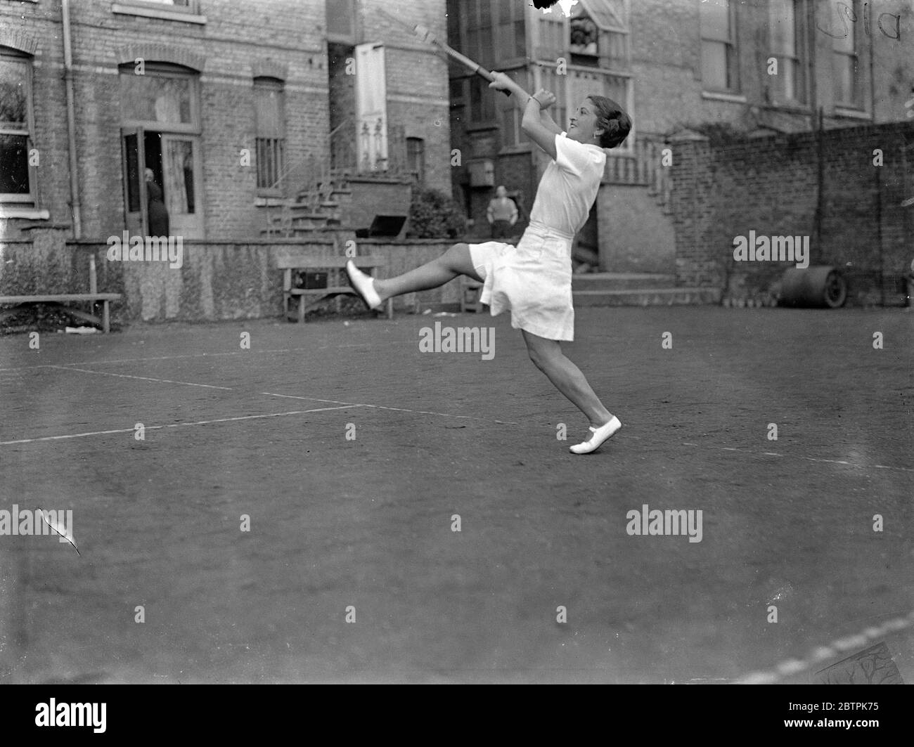 Gatto con ambizioni di tennis . Inseguito la palla di Senorita Lizana . Senorita Anita Lizana giocando con un gatto che ha insistito a inseguire la sua palla quando ha praticato al suo hotel a Putney . 30 marzo 1935 Foto Stock