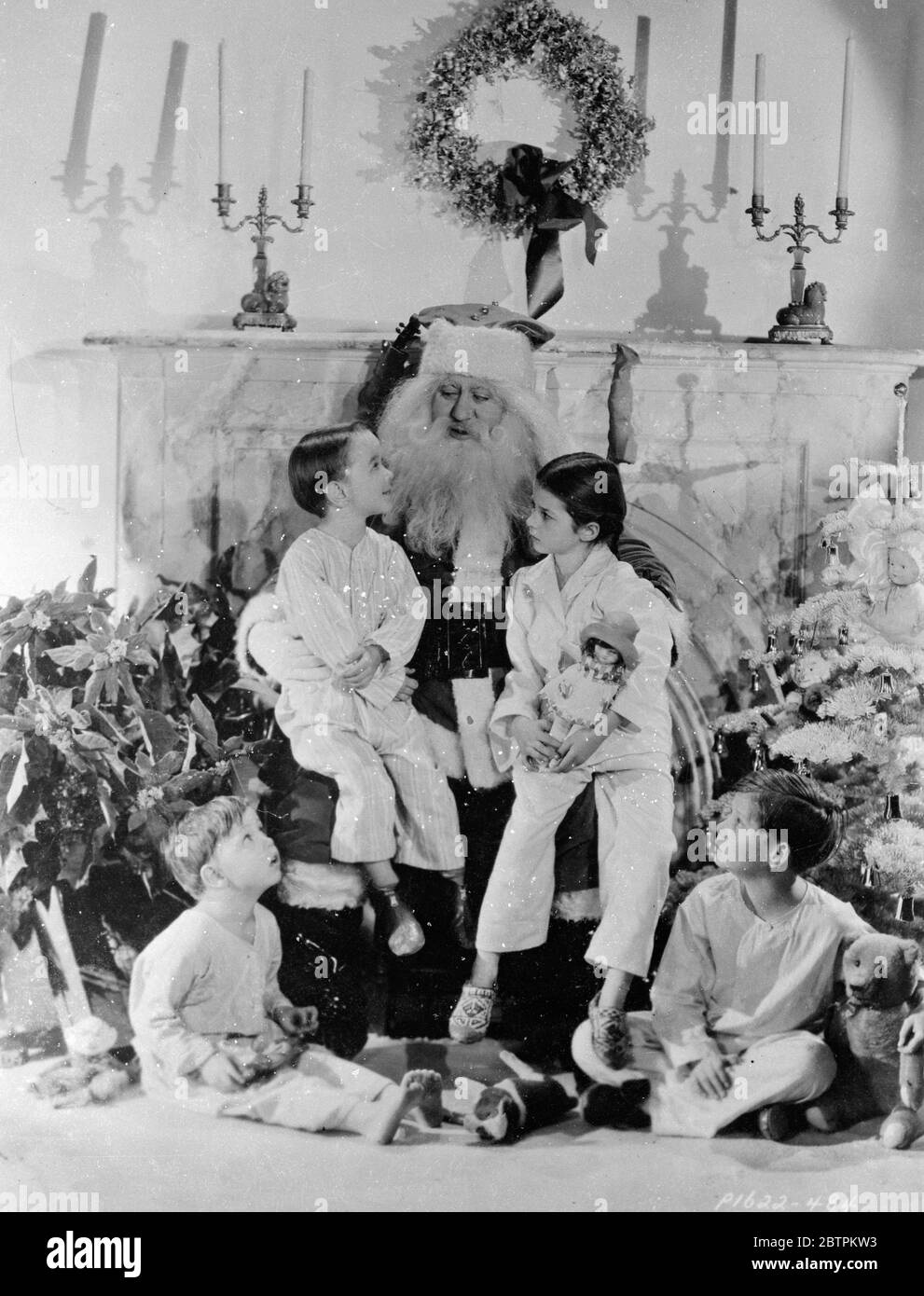 Santa racconta la storia . Abbracciando i loro giocattoli di Natale , quattro dei giovani attori di film di Hollywood ascoltano aperto il boccaglio alle meravigliose storie di Padre Natale , che catturarono prima che potesse fuggire sulla sua slitta di renna . Billy Lee e Virginia Weidler catturarono il posto d'onore sul grembo dell'uomo , da Baby le Roy ( a sinistra ) e Bannie Bartlett trovò che il pavimento era quasi buono . 23 dicembre 1935 Foto Stock