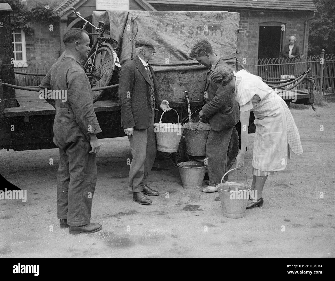 Aumento della siccità nel Buckinghamshire . I villaggi ricevono le forniture di acqua dai lorrys . Foto spettacoli , abitanti di Kingswood , Buckinghamshire , che ricevono le loro forniture d'acqua da un carro armato . 9 agosto 1935 Foto Stock