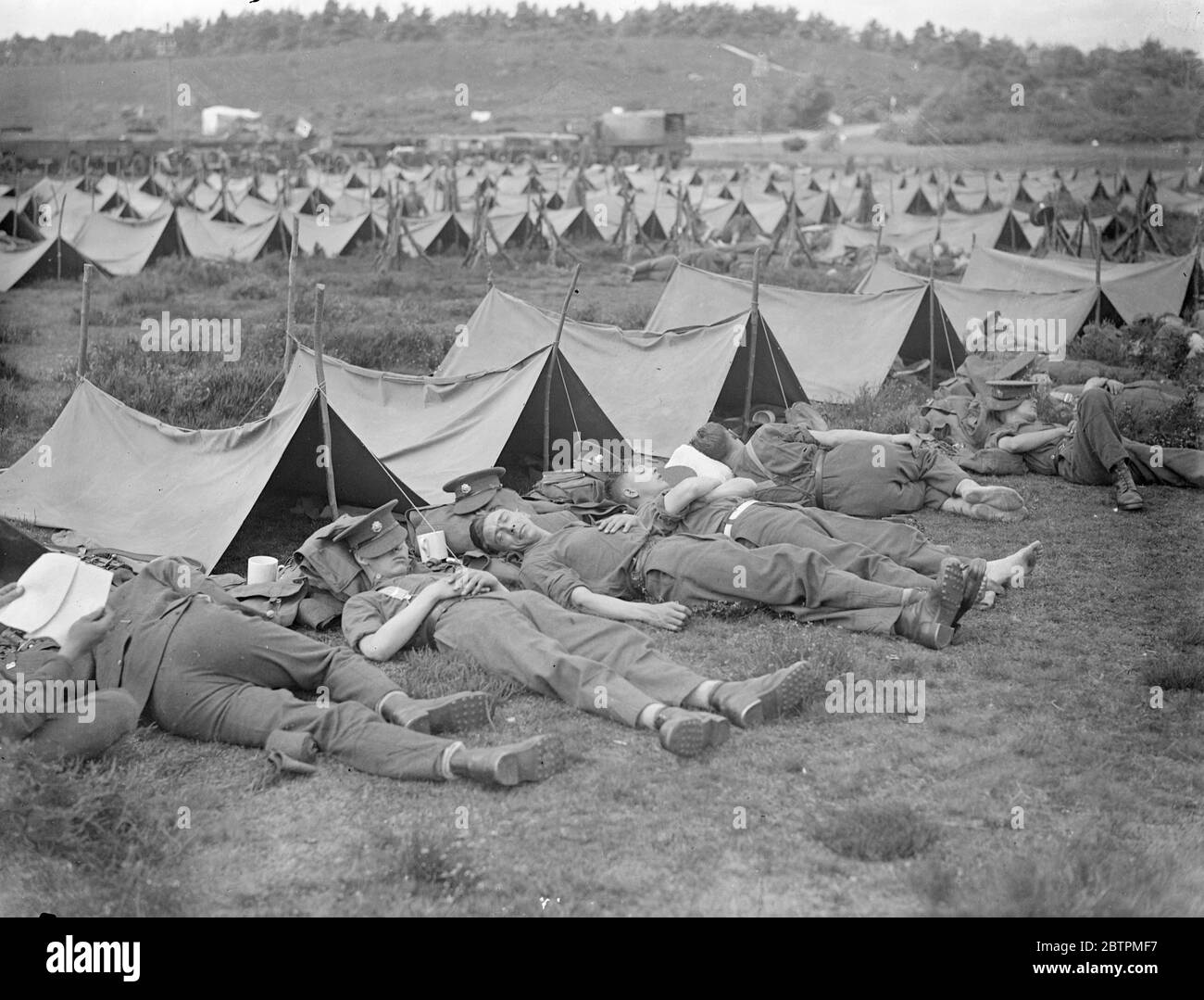 Riposa il marzo . Truppe di Aldershot su manovre . Marciando da Aldershot la mattina presto , le truppe della seconda Divisione, Marlborough Lines , stanno marciando attraverso Sussex sulle loro manovre annuali . Stanno compiendo azioni mimiche il marzo . Foto spettacoli : truppe della 2 ° Divisione , Marlborough Lines , riposando al sole sul Frensham Common , Aldershot 27 lug 1936 Foto Stock