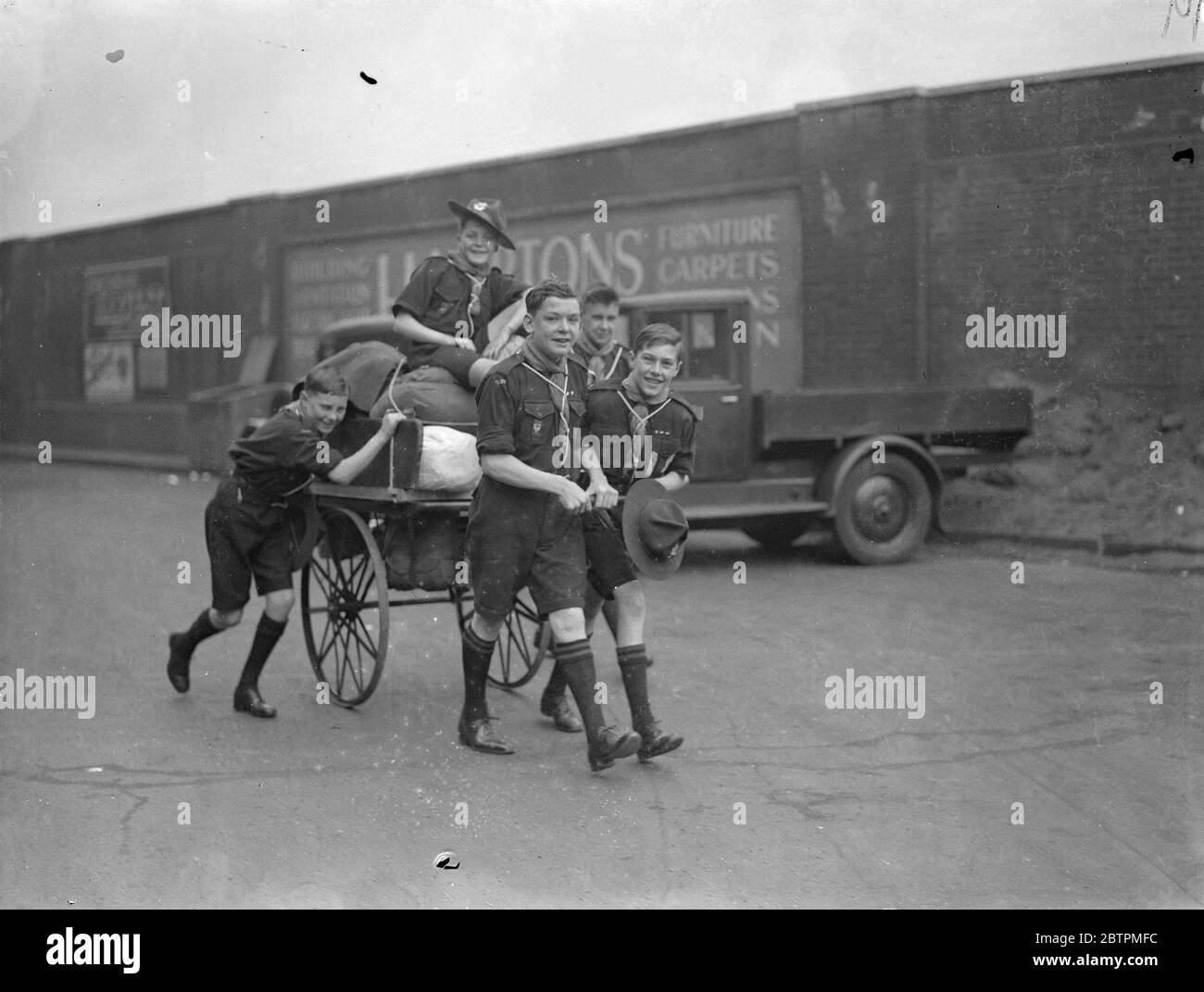 Partenza per Whitsun . I londinesi si riversano in costa e in campagna per trascorrere Whitsuntide all'aria aperta. Foto mostra , scout tirando il loro carrello caricato a Waterloo . 30 maggio 1936 Foto Stock