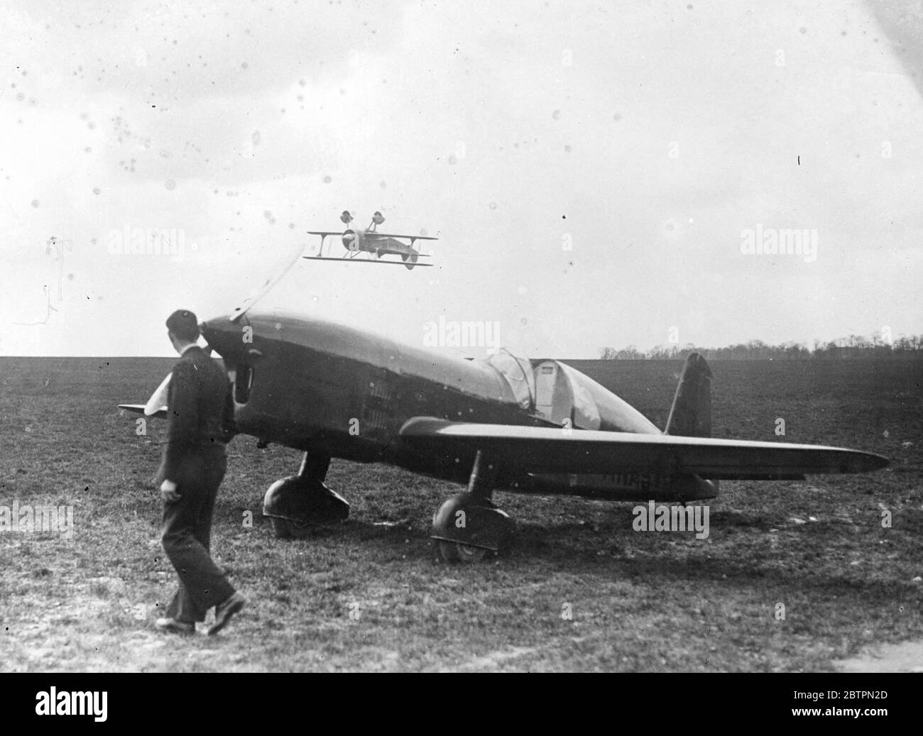 Ali per prime. M Massotte, uno dei principali piloti di stunt della Francia, quasi a skimming il campo di atterraggio come pratica capovolto volare all'aerodromo di Buc per il grande francese uno spettacolo il 25 aprile. 20 aprile 1937 Foto Stock