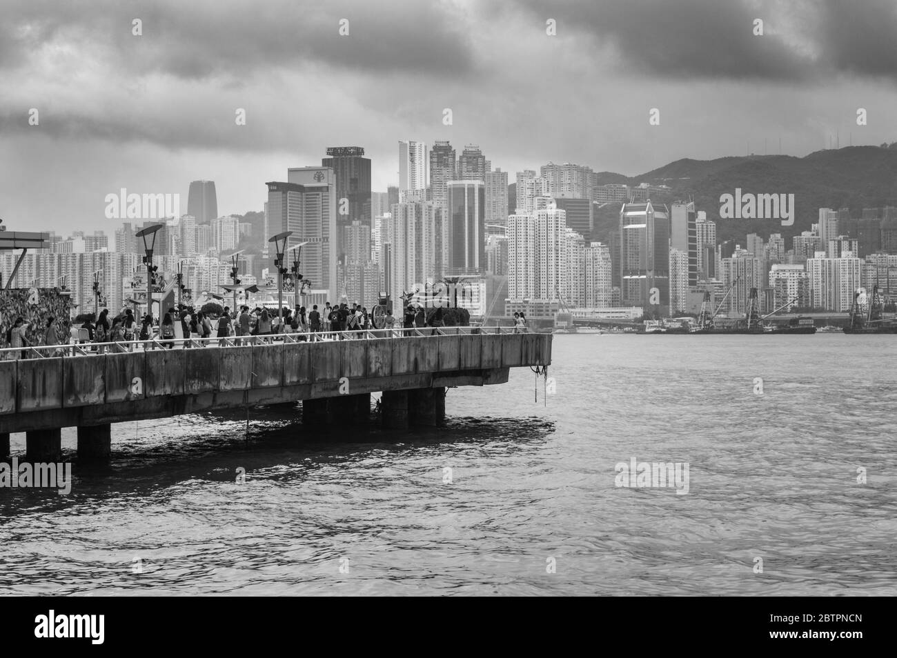 Hong Kong / Cina - 23 luglio 2015: La gente guarda l'iconico skyline di Hong Kong dalla passeggiata di Tsim Sha Tsui Foto Stock