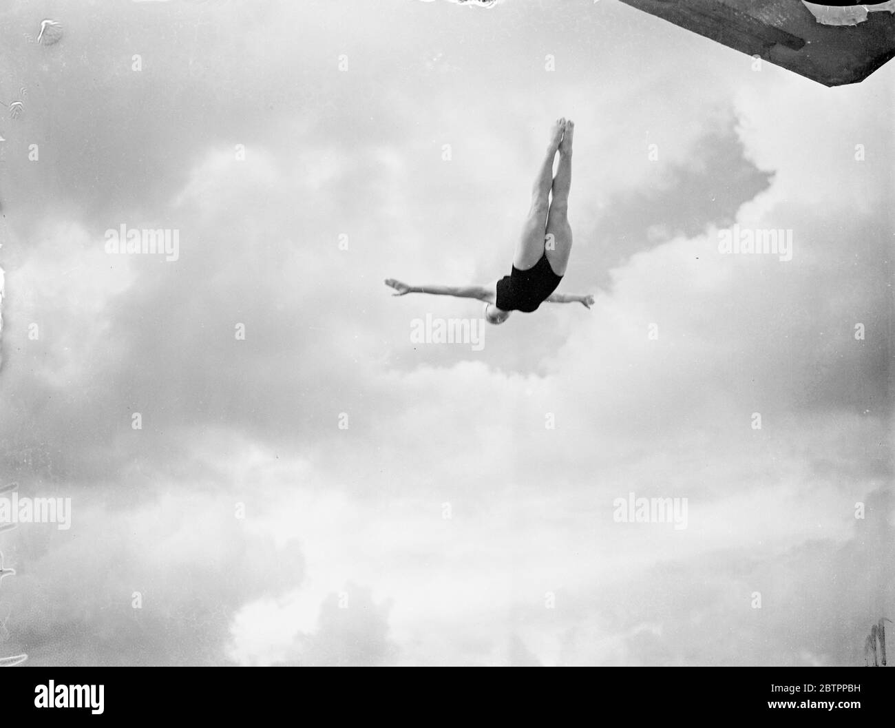 Fluttuante nelle nuvole. Betty Slade, titolare di un trampolino inglese, di 17 anni, ha fatto il suo debutto in un campionato di immersione in alto quando ha sfidato per i campionati delle contee del sud al Purley Way Pool di fronte all'aeroporto di Croydon. Spettacoli fotografici, Betty Slade in swallow dive, grazia birdlike, attraverso le nuvole a Croydon, Surrey. 30 giugno 1938 Foto Stock