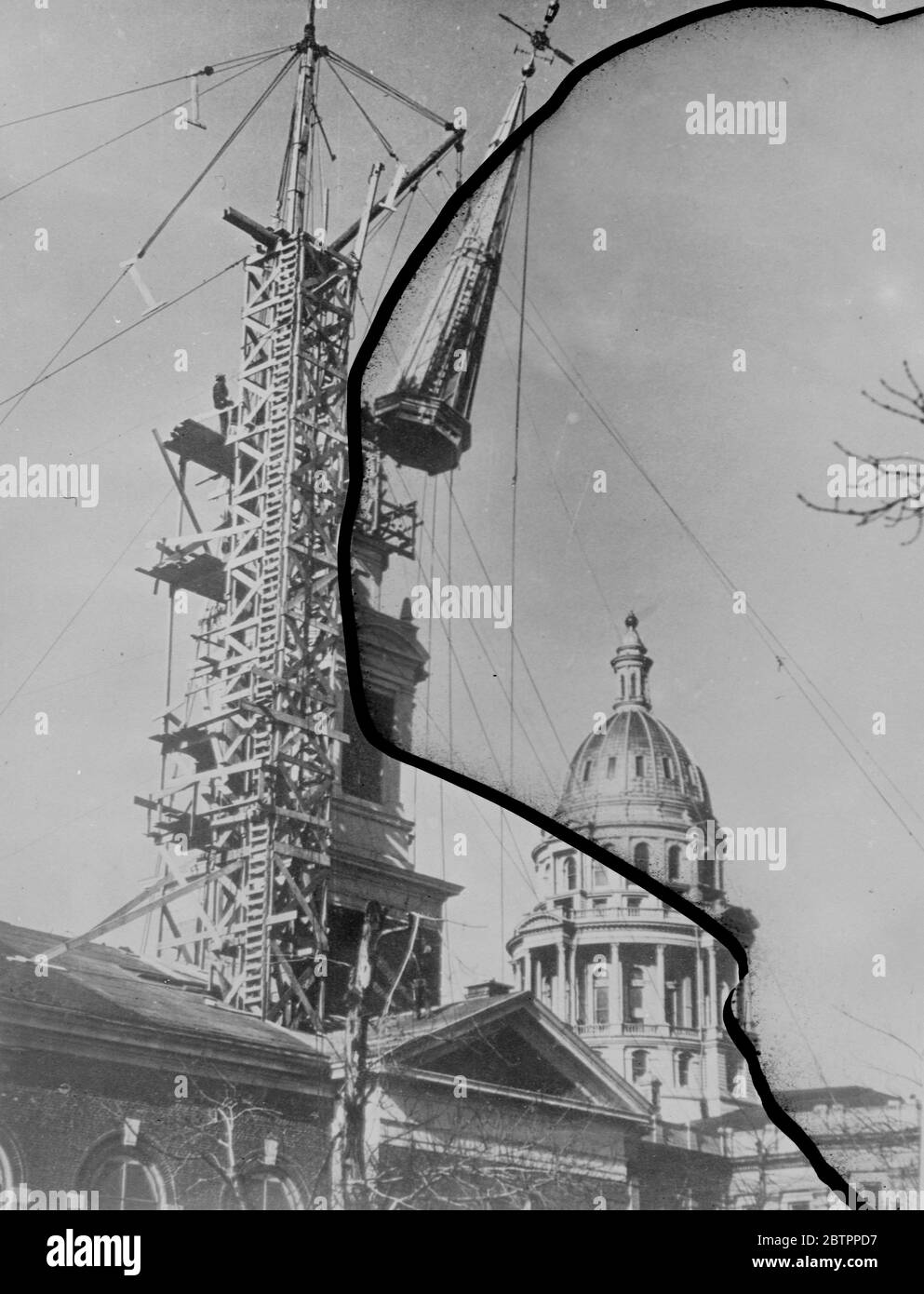 La Chiesa riceve il suo campanile. Il mistero di come si costruisce un campanile della chiesa è risolto in questa foto. La guglia di 160 metri sulla nuova prima chiesa Battista di Denver, Colorado, è stata costruita a terra e poi sollevata in posizione da derrick mentre una folla di diverse migliaia di persone guardava. Foto mostra, il campanile della nuova prima chiesa Battista che viene innalzata in posizione a Denver, Colorado. Sullo sfondo è la cupola dorata del campidoglio. 4 febbraio 1938 Foto Stock