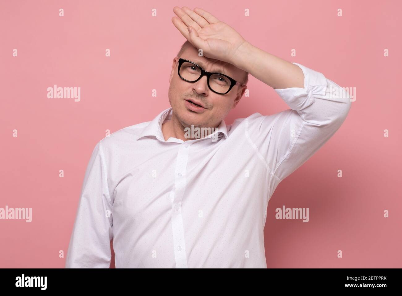 l'uomo maturo in camicia bianca è preoccupato e stanco durante il caldo tempo estivo. Foto Stock