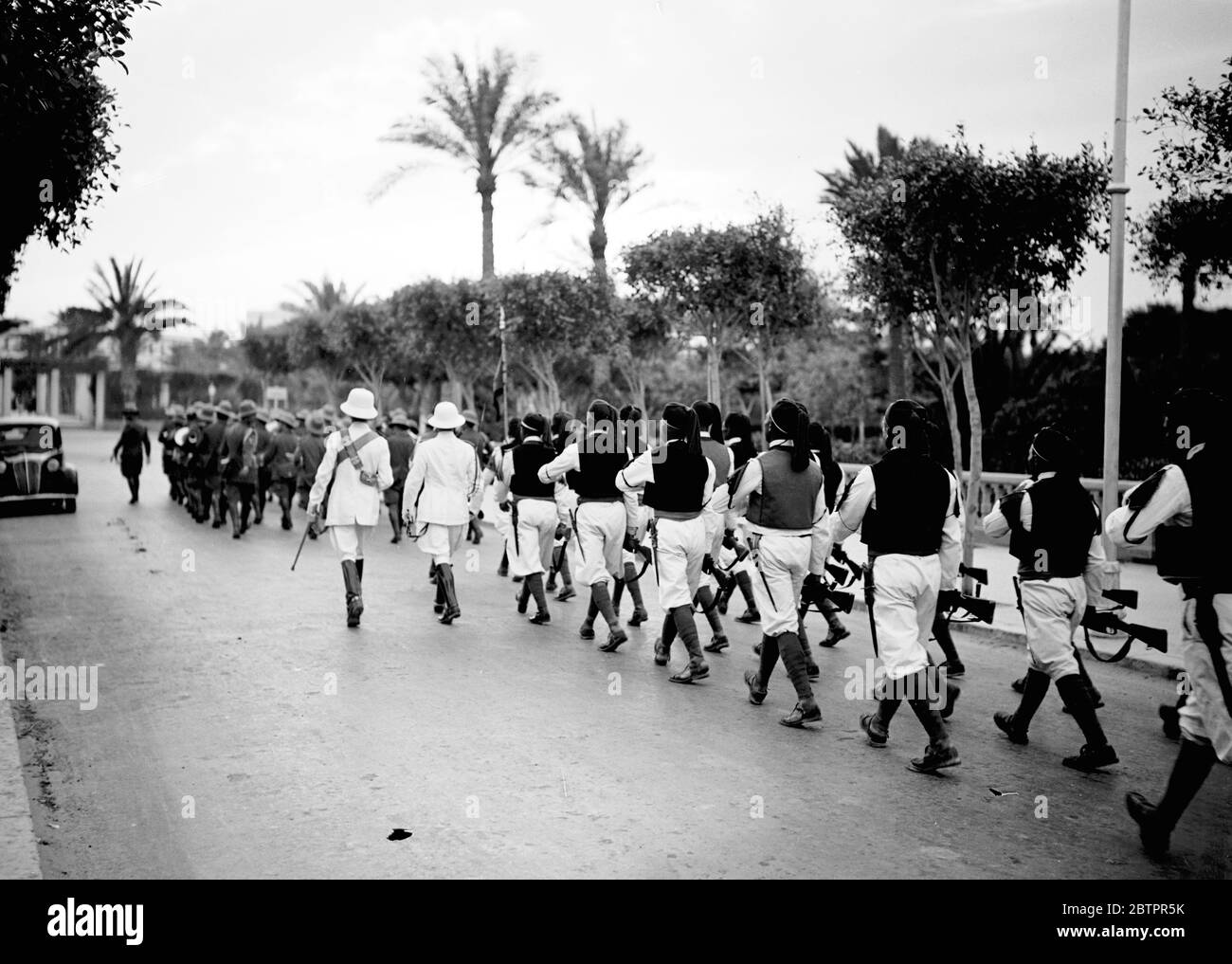 Tripoli. Truppe in parata in uniforme tradizionale, con ufficiali italiani in uniforme. Foto Stock