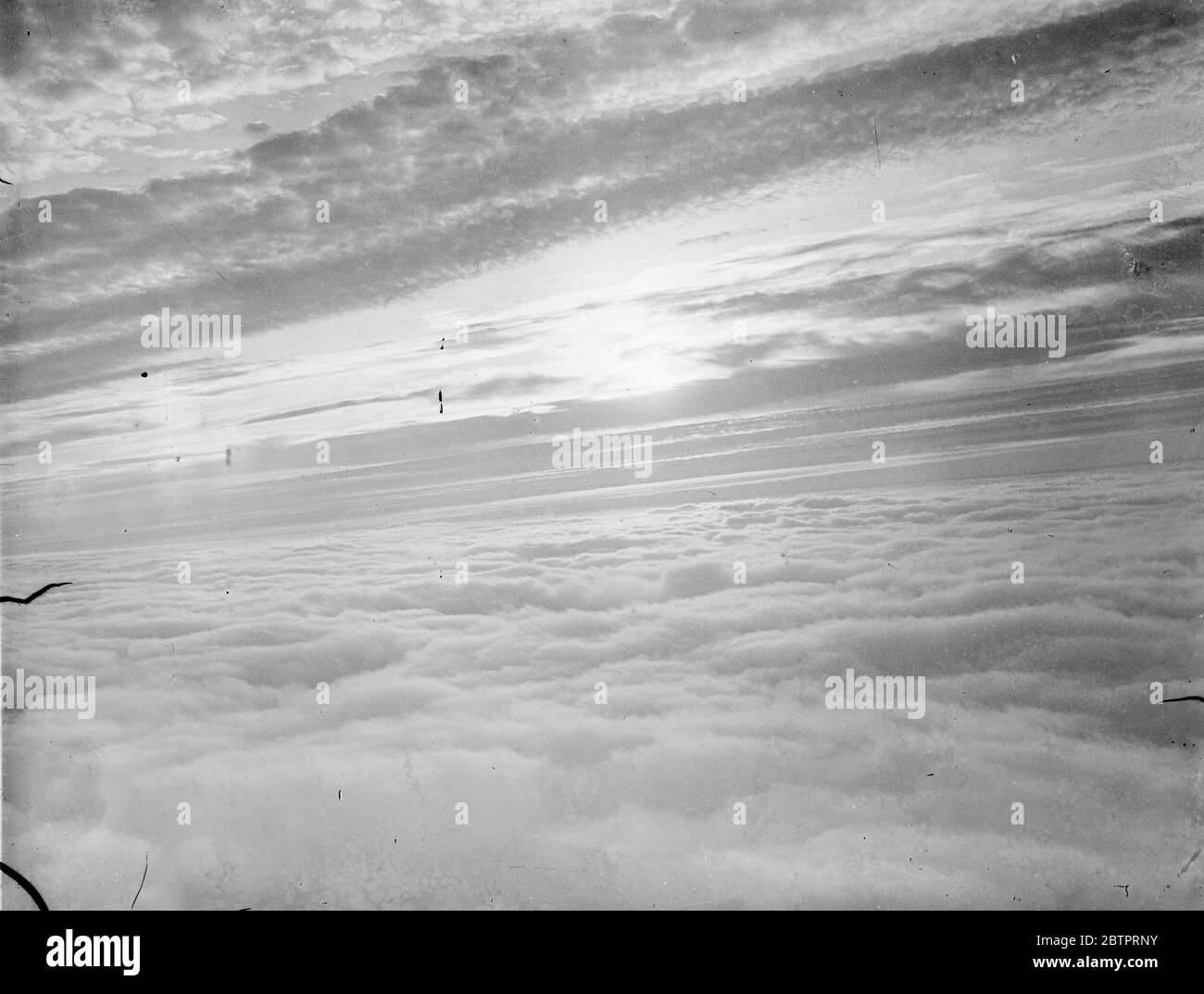 Questa è una nebbia inglese. Questa fotografia, tratta dall'aria sul Devonshire, Inghilterra. Mostra il tramonto su una sponda della nebbia che scese fino a una profondità di 4000 metri. La nebbia si estendeva dai sobborghi di Londra a Plymouth per circa 200 chilometri. La foto è stata fatta da un fotografo di notizie del pianeta, girando su un aereo speciale da un incarico a Plymouth. 20 ottobre 1937 Foto Stock