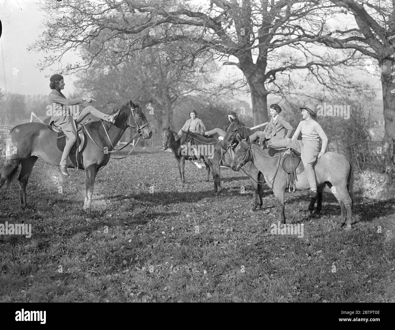 Ricerca guasti. La sig.ra Deirdre Kenny, che a 15 anni di età, si ritiene sia la più giovane amante di equitazione della Gran Bretagna, mostrando ai suoi allievi come scendere alla Paddocks Riding School, Mill Hill, Middlesex, che possiede e superintende. La sig.ra Kenney è sul suo pony 'Opal' (a sinistra) 13 novembre 1937 Foto Stock