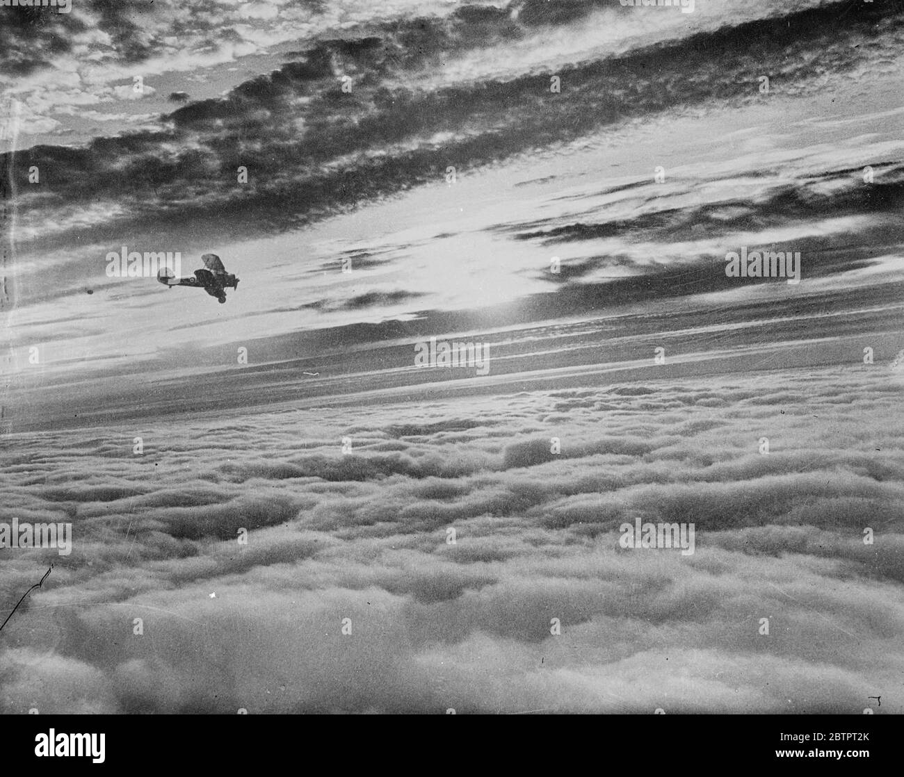 Questa è una nebbia inglese. Questa fotografia, tratta dall'aria sul Devonshire, Inghilterra. Mostra il tramonto su una sponda della nebbia che scese fino a una profondità di 4000 metri. La nebbia si estendeva dai sobborghi di Londra a Plymouth per circa 200 chilometri. La foto è stata fatta da un fotografo di notizie del pianeta, girando su un aereo speciale da un incarico a Plymouth. Foto mostra un gladiatore Gloster combattente della RAF silhouette al tramonto. 20 ottobre 1937 Foto Stock