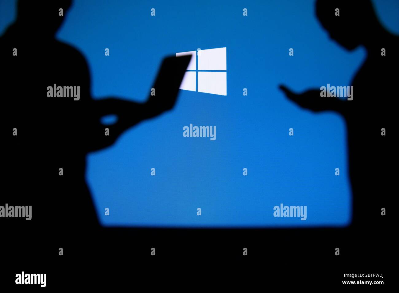 NEW YORK, STATI UNITI, 25. MAGGIO 2020: Sistema operativo grafico Microsoft Windows . Giovane uomo d'affari e donna che chiacchiera su smartphone e laptop. Azienda lo Foto Stock