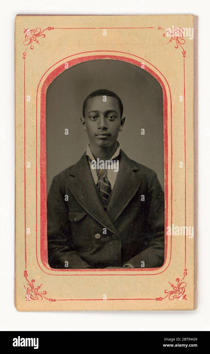 Tintype di un uomo. Un tipo di uomo afro-americano non identificato che indossa una cravatta, una giacca a doppia birra e un colletto alto. La piastra si trova all'interno di un telaio di carta. Foto Stock