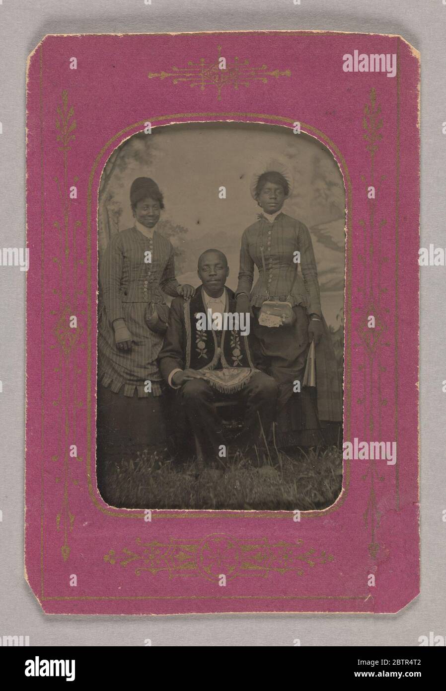 Tintype fotografia di James Turner Master Mason con due donne. Tintype fotografia di fratello James Turner, Master Mason nella Loggia Celestiale di Rhode Island, che è seduto indossando grembiule masonic è fiancheggiato da due donne, suore presumbabilmente nella ausiliaria delle donne del Lodge che hanno entrambe le mani poggiate sulle spalle di Turner. Foto Stock