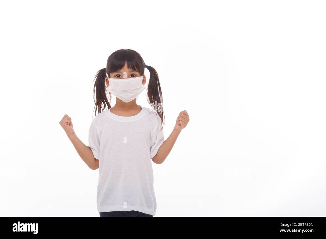 asia ragazza che indossa la maschera per proteggere contro Coronavirus, ragazza mostra un pugno incoraggiare a combattere il concetto di malattia contagiosa fermare il virus Covid 19 focolaio a. Foto Stock