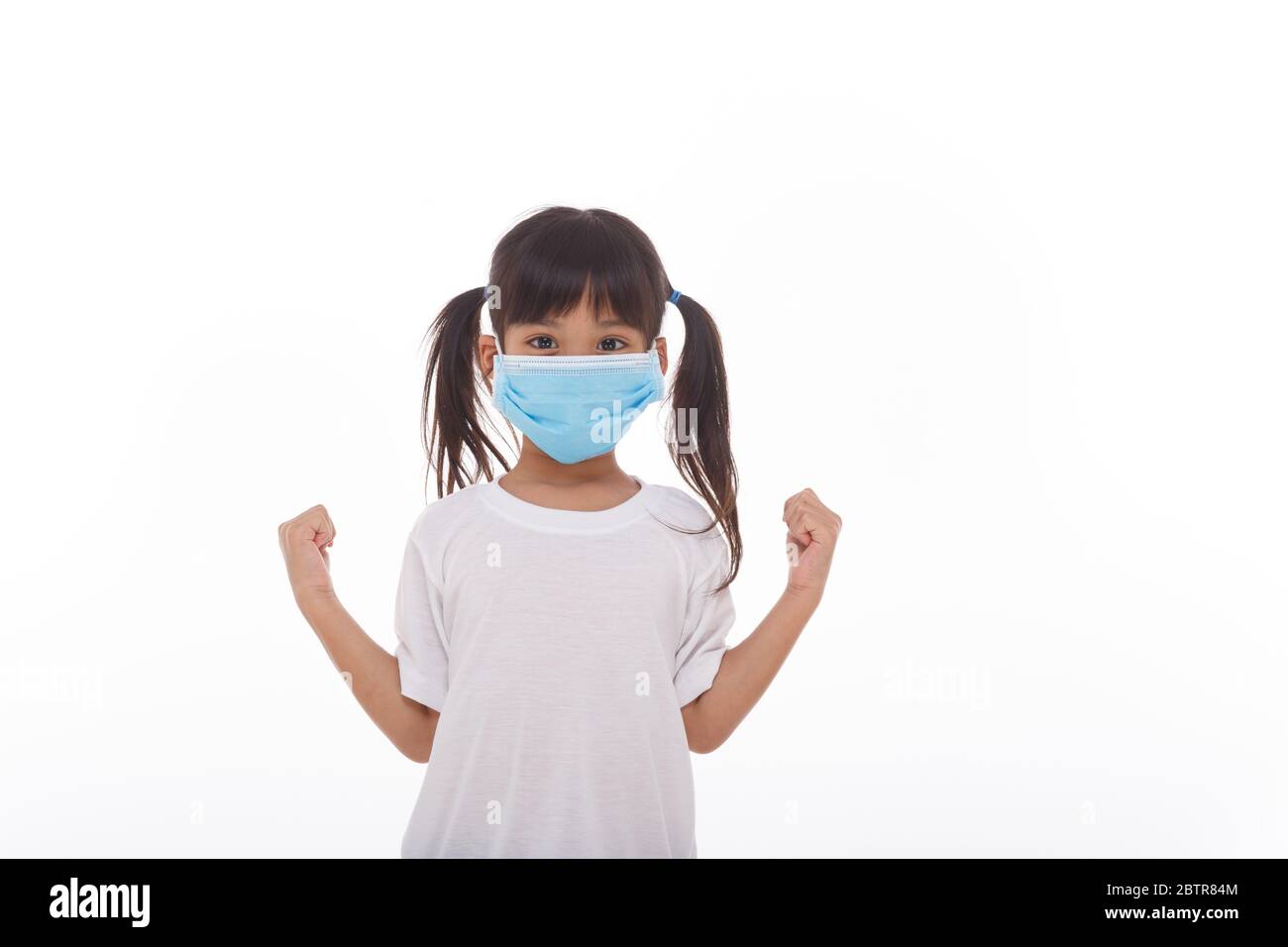 asia ragazza che indossa la maschera per proteggere contro Coronavirus, ragazza mostra un pugno incoraggiare a combattere il concetto di malattia contagiosa fermare il virus Covid 19 focolaio a. Foto Stock