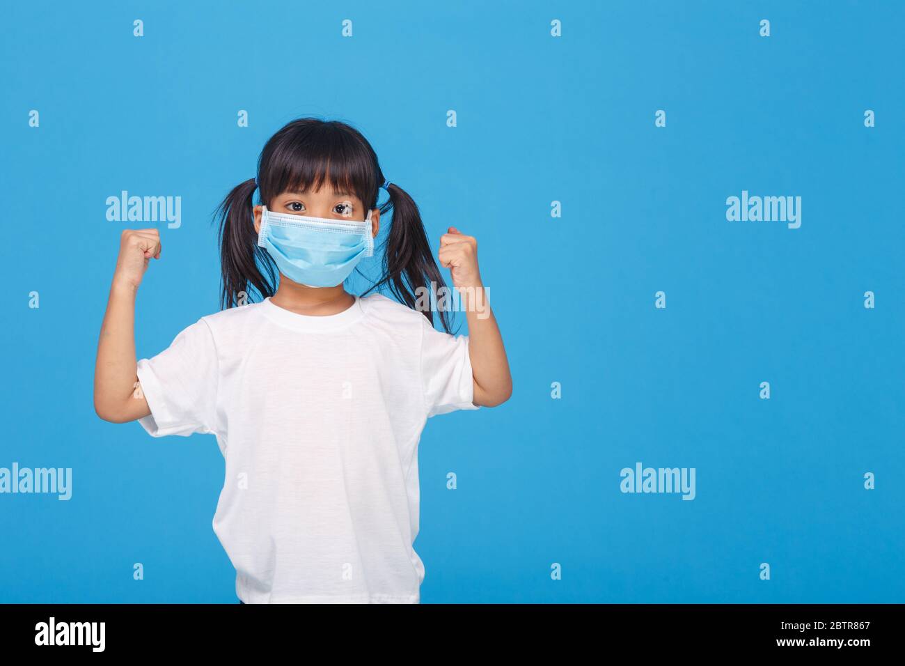 asia ragazza che indossa la maschera per proteggere contro Coronavirus, ragazza mostra un pugno incoraggiare a combattere il concetto di malattia contagiosa fermare il virus Covid 19 focolaio a. Foto Stock