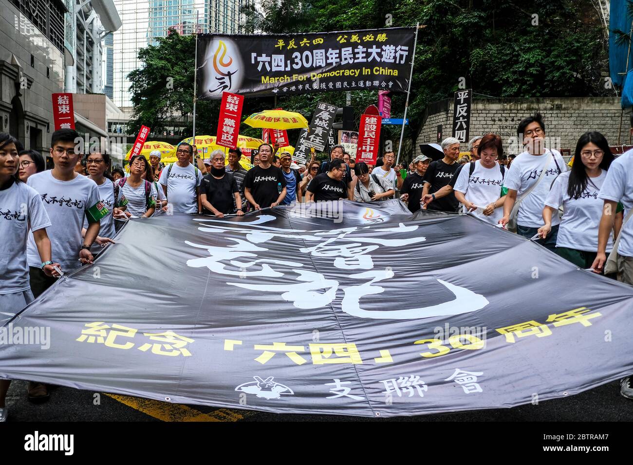 I manifestanti hanno tenuto un'enorme bandiera durante una marcia in vista del 4 giugno anniversario.per il trentesimo anno consecutivo, migliaia di manifestanti hanno marciato per il Centro di Hong Kong, in commemorazione dell'anniversario del massacro di Piazza Tiananmen del 1989 a Pechino. Coloro che hanno partecipato a questo raduno sostengono la democrazia e i diritti umani, sperano che il governo centrale cinese possa fermare il sistema di governo di un partito. Foto Stock