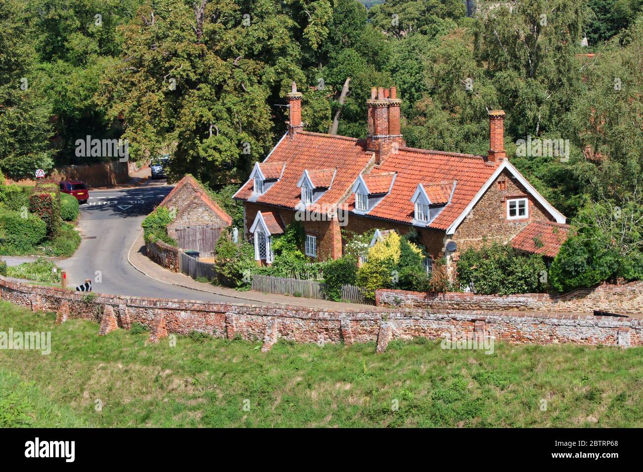 Tradizionali cottage piastrellati in pietra a lato di Lynn Road Castle Rising in Norfolk preso da una posizione elevata Foto Stock