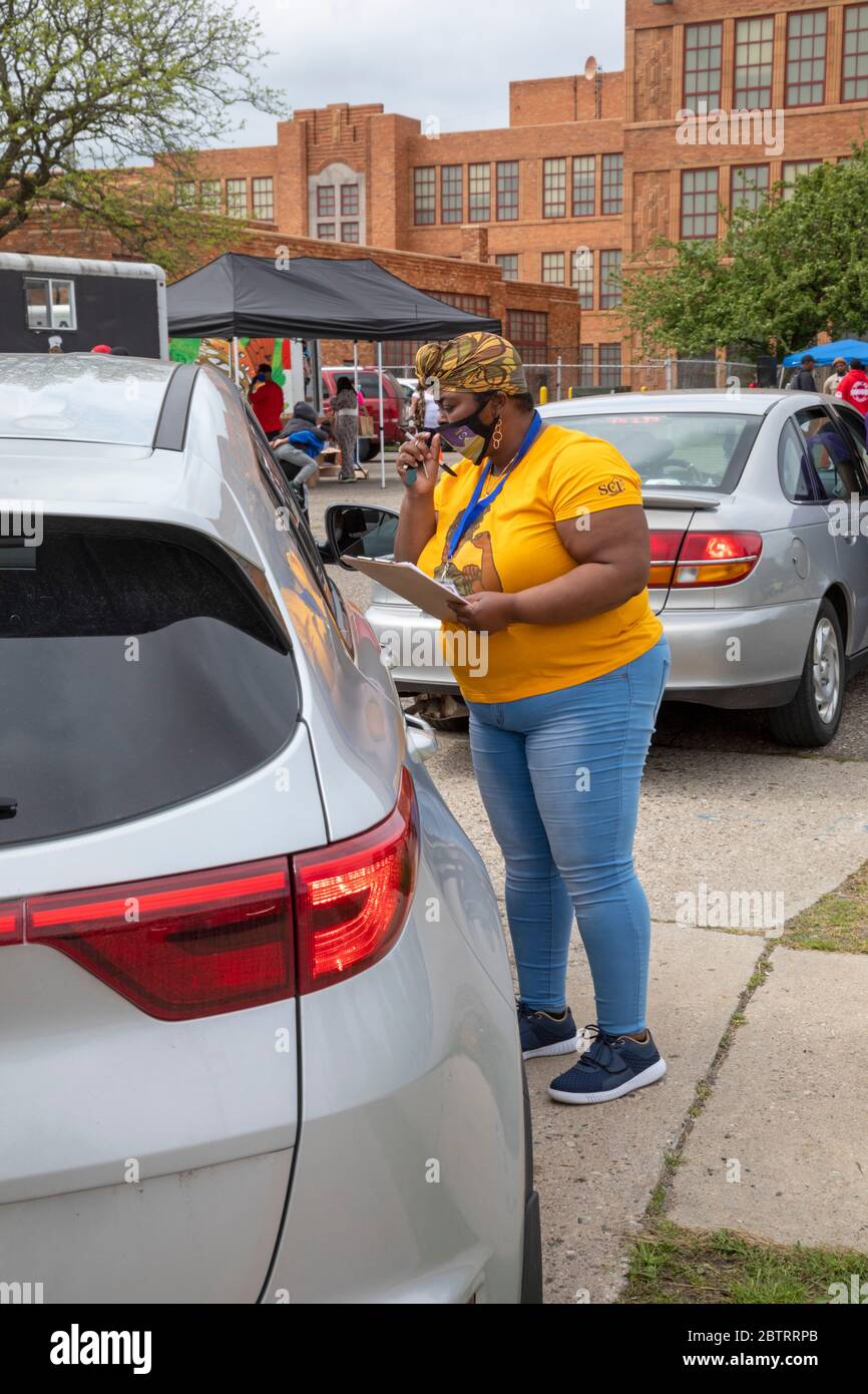 Detroit, Michigan - i volontari registrano le persone per votare quando arrivano per una distribuzione gratuita di cibo durante la pandemia del coronavirus. Foto Stock