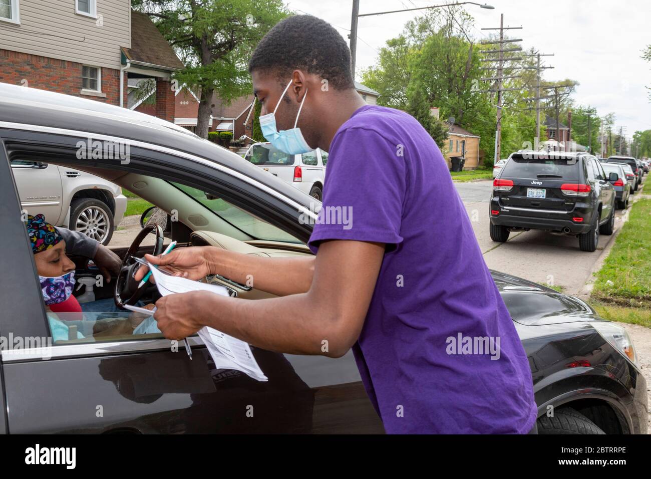 Detroit, Michigan - i volontari registrano le persone per votare quando arrivano per una distribuzione gratuita di cibo durante la pandemia del coronavirus. Foto Stock