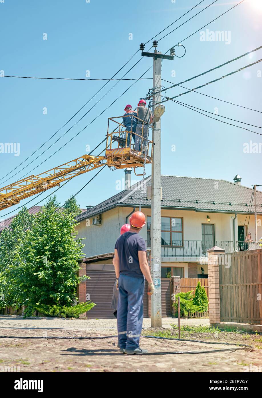 elettricista in una torre per auto per riparare le linee elettriche Foto Stock